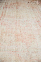 Distressed vintage Oushak carpet texture showing blush rose, dusty rose, and cotton white.