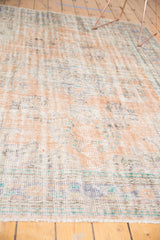 Vintage distressed Oushak rug surface with mostly even wear and faded apricot, ivory tones.