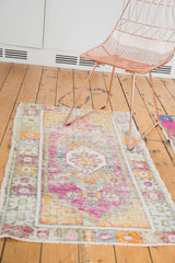 Distressed vintage Oushak rug's texture with faded purple, tangerine, and ivory colors.
