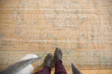 Distressed vintage Oushak carpet displaying soft apricot gold, seafoam mint, and even wear.