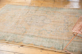Distressed vintage Oushak carpet with scalloped border and faded seafoam mint patterns.