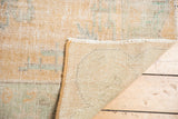 Hand-knotted Oushak rug foundation and secured fringe with faded apricot pile.
