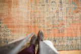 Textured distressed Oushak rug featuring faded floral motifs in blush, ivory, blues, and greens.