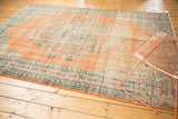 Worn texture and faded floral motifs on a distressed vintage Oushak carpet.