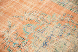 Distressed vintage Oushak rug, blush and ivory pile, faded blue floral, exposed foundation.