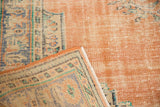 Worn dusty blush pile and patterned hand-knotted reverse of vintage distressed Oushak rug.