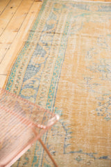 Distressed Oushak carpet, showing worn pile, exposed foundation, faded blue and mint.