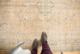 Distressed vintage Oushak rug with even wear, visible foundation, and sand, ivory, mint tones.
