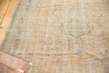 Distressed Oushak carpet texture showing localized foundation wear, in pale sand and faded mint.