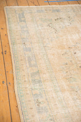 Distressed Oushak rug pile showing mostly even wear and soft mint green border.