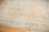 Distressed texture of vintage Oushak with faded sand, mint, and blue tones.