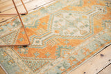 Faded burnt orange and seafoam green germinating seed motifs on vintage Oushak runner.