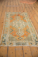 Distressed Oushak runner's germinating seed motif, elongated finial, and ivory fringe.