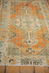 Distressed vintage Oushak runner, showing visible knot heads and faded orange, green geometric motifs.
