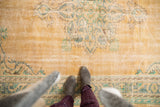 Distressed Oushak rug with faded apricot field, worn blue, mint green patterns, and mostly even wear.