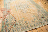 Distressed vintage Oushak carpet corner with faded apricot pile texture and blue-green Rococo motifs.