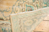 Distressed Oushak carpet with worn pile, secure fringe, and visible hand-knotted foundation.