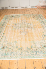 Textural distressed pile of vintage Oushak rug in faded apricot with blue Rococo motifs.