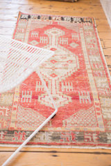 Textured vintage distressed Oushak rug pile with geometric red, ivory, and charcoal patterns.