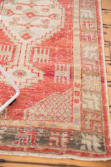 Geometric border detail of distressed Oushak runner, with cinnabar red, ivory, and charcoal tones.