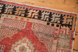 Vintage distressed Oushak rug corner detail with cinnabar red lattice, geometric border.