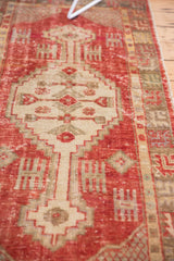 Distressed Oushak runner pile with worn cinnabar red, ivory, and visible foundation.