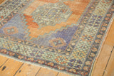 Vintage Distressed Oushak rug border features abrashed terracotta, faded blue, and pale gold.