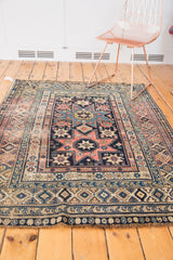 Collectible antique Shirvan rug's lower edge featuring geometric borders and starburst motifs.
