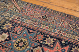 Nuanced geometric star motifs and vibrant borders on this hand-knotted antique Caucasian Shirvan rug.