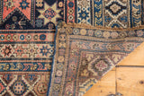 Hand knotted Antique Shirvan rug corner, displaying playful geometric starbursts, blush, navy, and ivory tones.