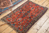 Upper corner of Lilihan rug showing cherry red ground, oversized floral motifs, and tattered end.