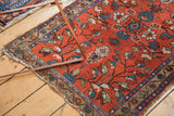 Lilihan rug corner showcasing cherry red field, vibrant blue border, and aged fringed end.