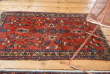 Lilihan rug corner: intricate beige floral border and cherry red main field.