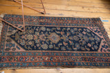 Kurdish Hamadan rug detail: navy field, serrated terracotta spandrel, and tattered fringe.