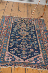 Blush pink corner spandrel, navy Herati motifs, and worn fringe of a vintage Kurdish rug.