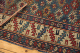 Antique Caucasian Shirvan rug's wide serrated leaf border and diminutive gul motifs.