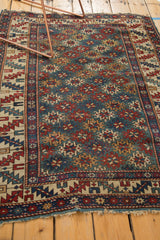 Bottom corner of the Shirvan rug, with tattered ends, ivory geometric serrated leaf border.