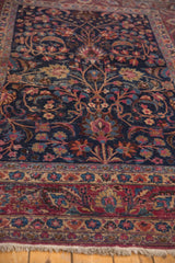 Tree-of-life, tendrils, flowers on navy blue vintage Meshed rug with wine red border.