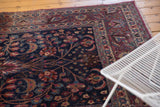 Vintage Meshed carpet: navy blue field with delicate floral patterns and visible wear.