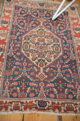Close-up of antique Senneh rug's main border with bold wine red, navy blue geometric motifs.