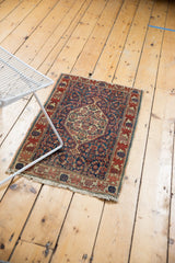 Antique Senneh rug corner with navy Herati field, detailed wine red border, tattered fringe.