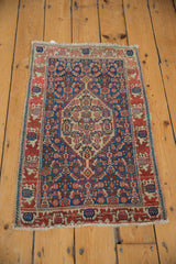Oversized serrated medallion and Herati motif on an antique Senneh rug with vibrant navy and red.
