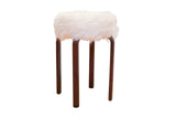 Alvar Aalto style stool with a fluffy white faux fur top and dark bentwood legs.