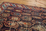 Late 19th century Caucasian rug with navy, red, sand oversized boteh patterns and localized wear.