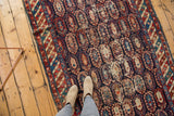 Antique Caucasian runner with allover boteh pattern, showing wear to pile, in navy, red, and sand.