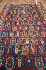 Antique Caucasian runner's worn navy field with staggered red and blue boteh pattern.