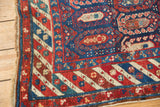 Antique Caucasian runner corner: navy, red, and sand geometric border with visible wear.