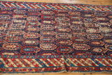 Antique Caucasian runner corner, rich navy field, vibrant boteh pattern, wear, and striped border.