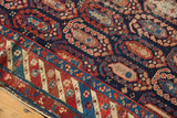 Antique Caucasian runner's navy field, oversized botehs, and distinct geometric border with knot wear.