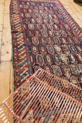 Antique Caucasian runner's navy blue, red boteh pattern, geometric borders, and visible wear.